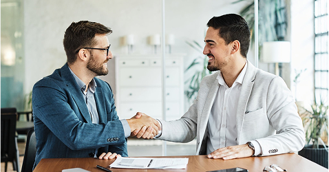Two professionals shaking hands over a property transfer agreement with Eagle Peak Conveyancing.