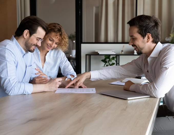 Eagle Peak Conveyancing professional helping a couple review and sign a property settlement document.