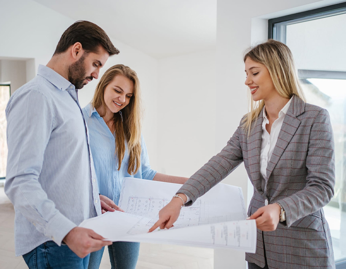 Eagle Peak conveyancer reviewing and explaining off the plan property blueprints with a happy couple.