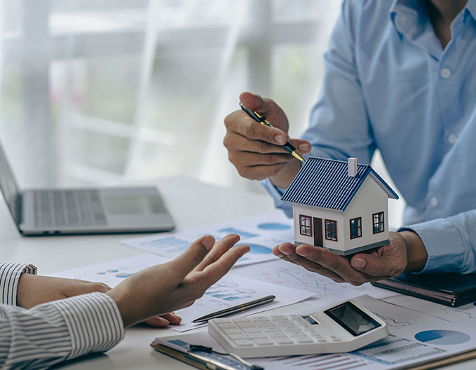 Eagle Peak business conveyancer explaining a small business or commercial property transaction while holding a model house.